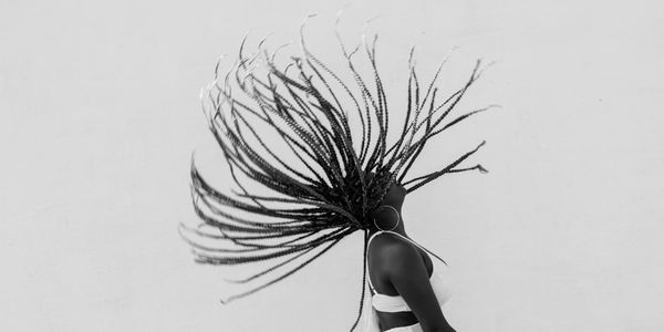 Silhouette of a person in a strong yoga warrior pose against a minimal backdrop.